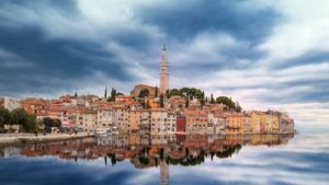 die Stadt Rovinj vom Meer aus gesehen und ihre Spiegelung auf dem Wasser
